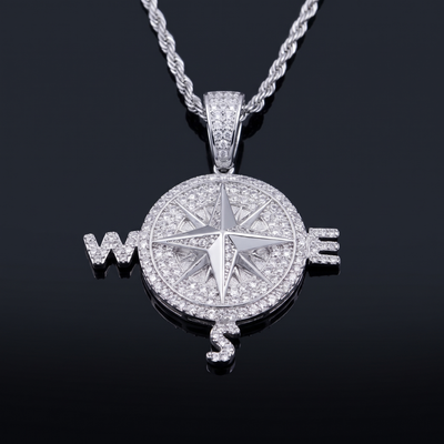 Pendentif boussole finition or blanc serti de zircones cubiques, rose des vents et lettres W, E, S, sur chaîne torsadée