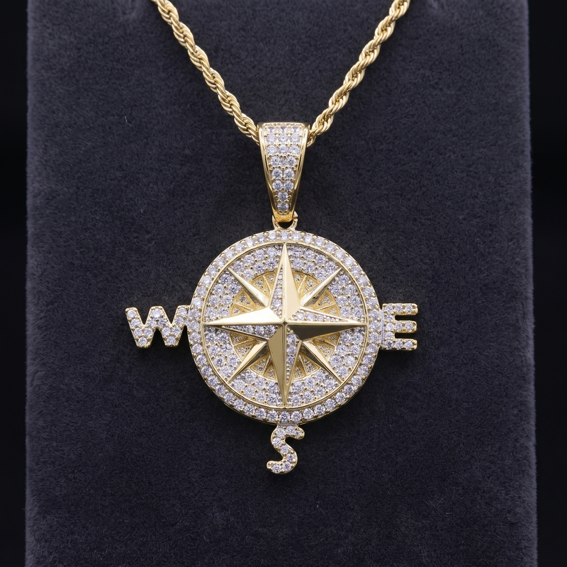 Pendentif boussole plaqué or jaune serti de zircones cubiques, rose des vents et lettres W, E, S, sur chaîne torsadée